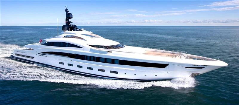 Yacht cruising through the water on a clear day with bright blue skies and deep blue waters.