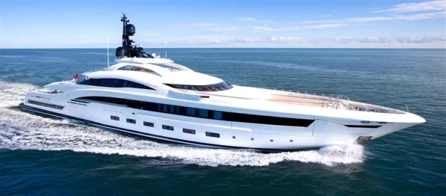 Yacht Yacht cruising through the water on a clear day with bright blue skies and deep blue waters.